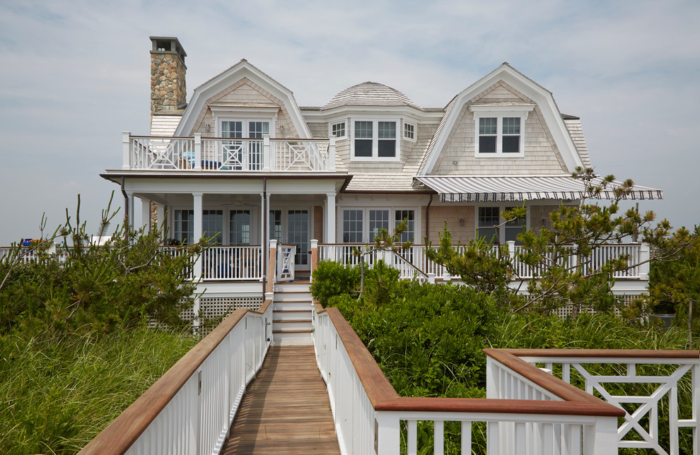 Стильный дизайн: большой, двухэтажный, деревянный, серый дом в морском стиле с мансардной крышей - последний тренд