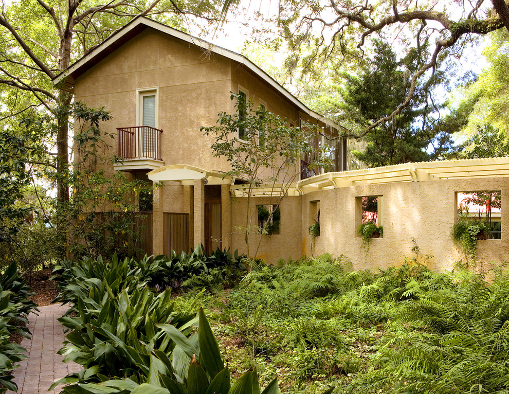 Пример оригинального дизайна: двухэтажный дом среднего размера в современном стиле с облицовкой из цементной штукатурки