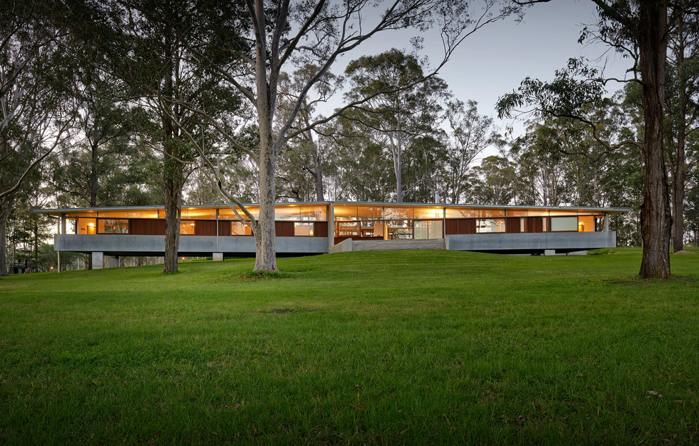 Cette image montre une grande façade de maison minimaliste de plain-pied avec un toit à deux pans.