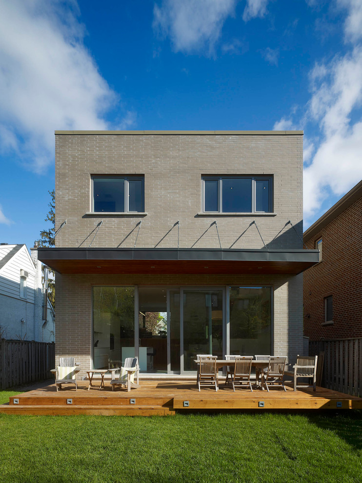 Exemple d'une façade de maison grise tendance en brique de taille moyenne et à un étage avec un toit plat.