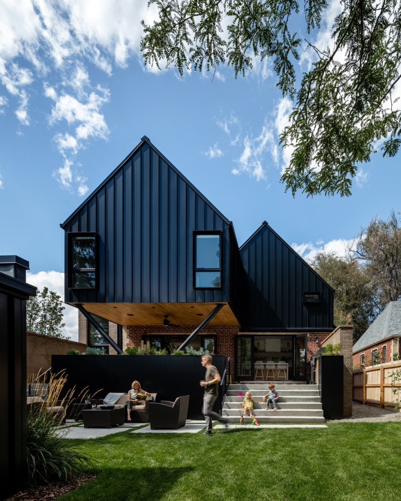 Imagen de fachada de casa negra de estilo de casa de campo con tejado a dos aguas
