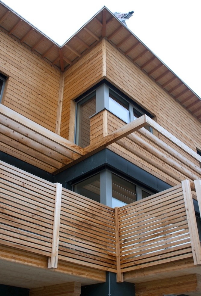 Esempio della facciata di una casa marrone moderna a due piani con rivestimento in legno