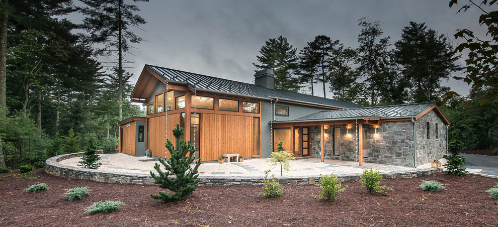 Aménagement d'une grande façade de maison grise moderne de plain-pied avec un revêtement mixte et un toit à deux pans.