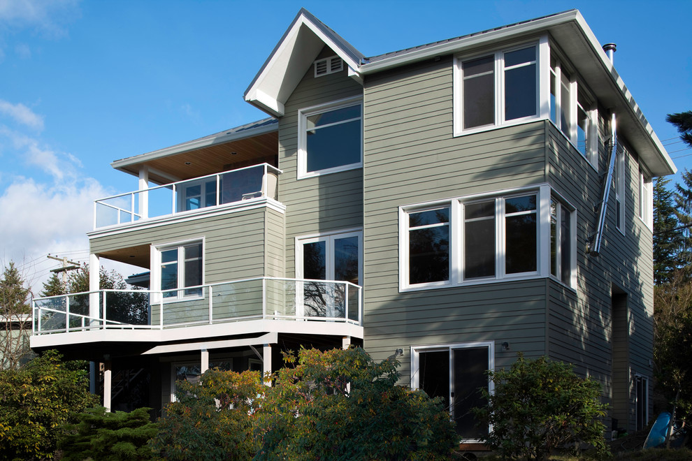 This is an example of a medium sized and green contemporary house exterior in Seattle with three floors and wood cladding.