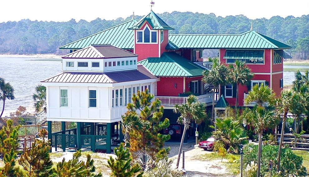 Inspiration for a large coastal multicolored two-story concrete fiberboard house exterior remodel in Miami with a hip roof and a metal roof