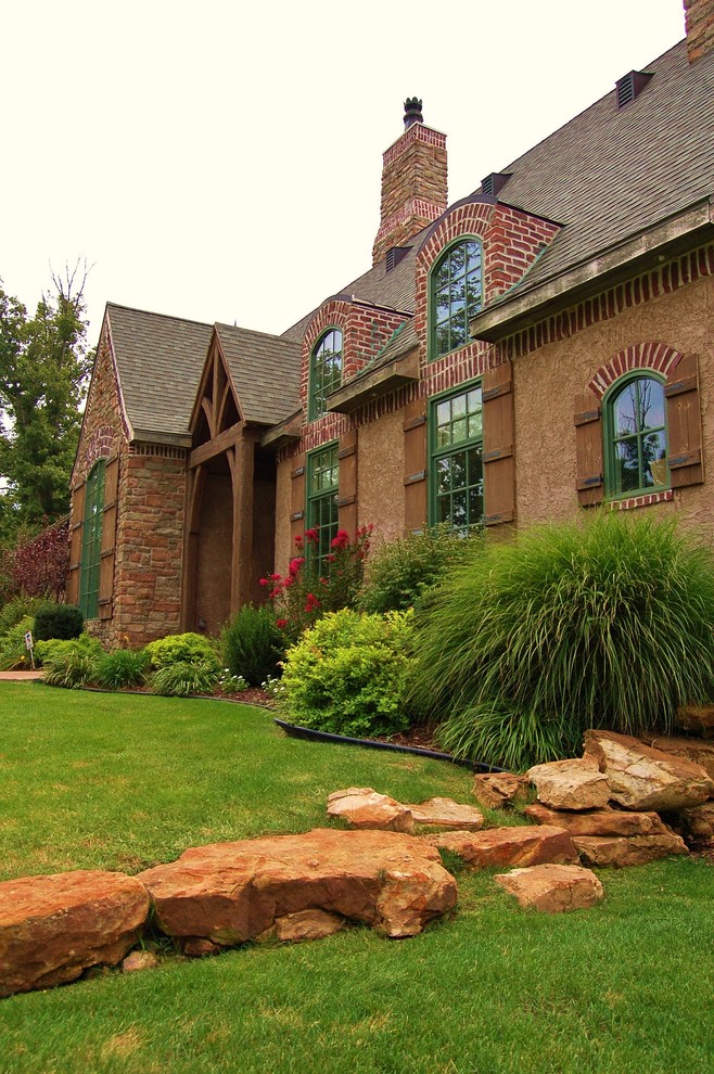 Design ideas for a large and red traditional two floor brick house exterior in Other with a pitched roof.