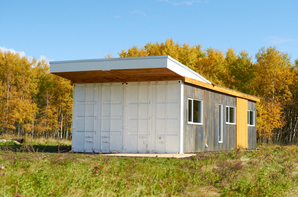 Пример оригинального дизайна: маленький, одноэтажный, белый дом из контейнеров, из контейнеров в стиле модернизм с облицовкой из металла и плоской крышей для на участке и в саду