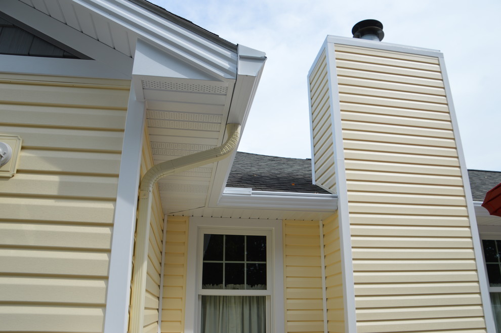 Cette photo montre une façade de maison jaune chic de taille moyenne et de plain-pied avec un revêtement mixte.