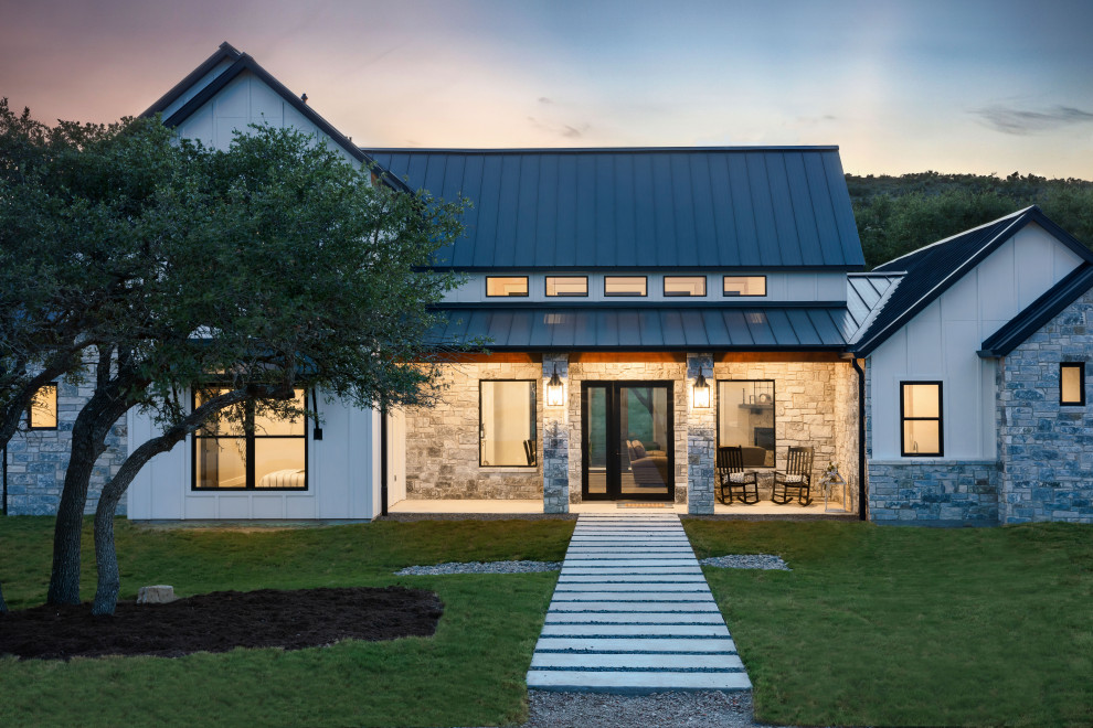 Idées déco pour une façade de maison blanche campagne avec un toit noir.