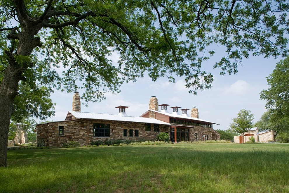 Idee per la villa beige country a un piano di medie dimensioni con rivestimento in pietra, tetto a capanna e copertura in metallo o lamiera