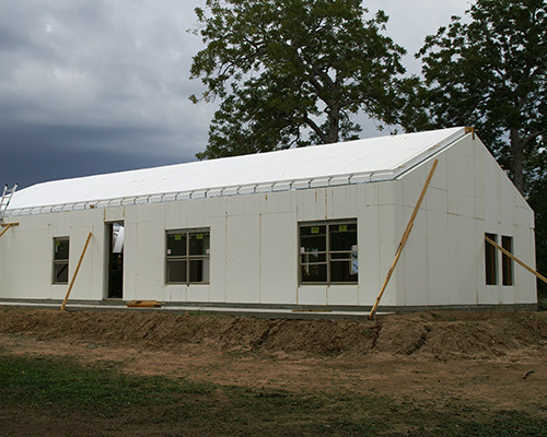 Imagen de fachada beige de estilo de casa de campo de tamaño medio de una planta con revestimiento de estuco