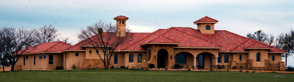 Idée de décoration pour une très grande façade de maison beige méditerranéenne en adobe de plain-pied avec un toit à quatre pans.