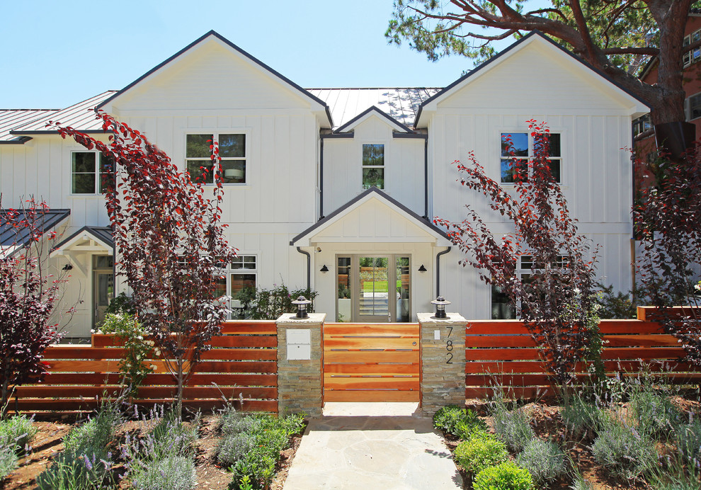 Inspiration for a white traditional two floor house exterior in Los Angeles with wood cladding.