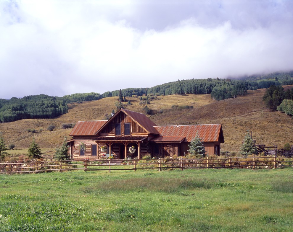 Foto della facciata di una casa rustica a due piani di medie dimensioni con rivestimento in legno