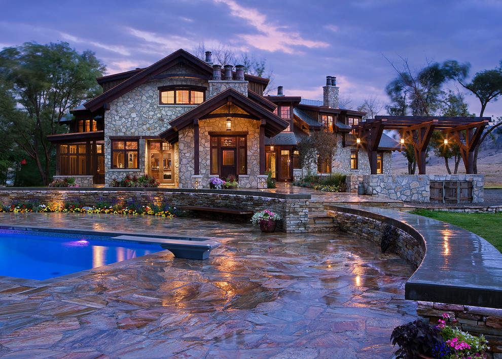 Expansive and beige rustic house exterior in Calgary with stone cladding.