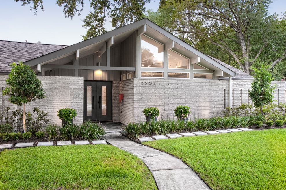 ヒューストンにあるお手頃価格の中くらいなミッドセンチュリースタイルのおしゃれな家の外観 (レンガサイディング) の写真
