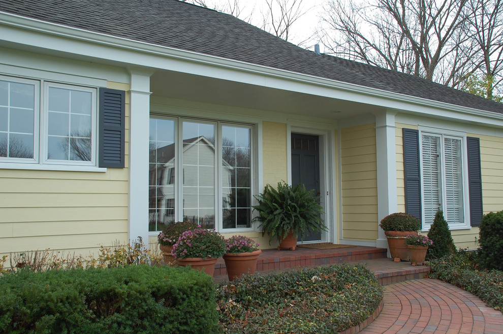 他の地域にある中くらいなトラディショナルスタイルのおしゃれな家の外観 (コンクリート繊維板サイディング、黄色い外壁) の写真