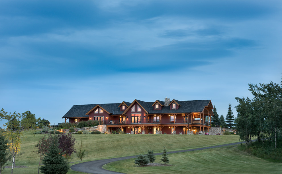 This is an example of a large and red rural house exterior in Calgary with three floors.