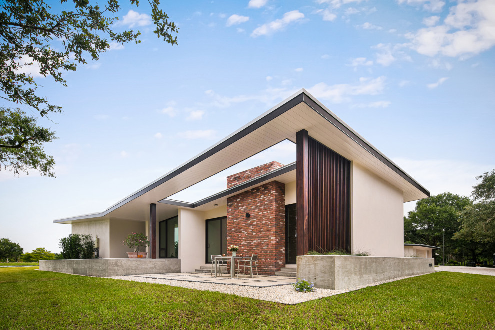 Ispirazione per la villa bianca contemporanea a un piano di medie dimensioni con rivestimento in mattoni e copertura in metallo o lamiera