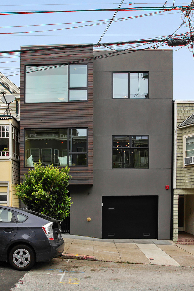 Modelo de fachada gris minimalista de tamaño medio de tres plantas con revestimiento de estuco y tejado plano