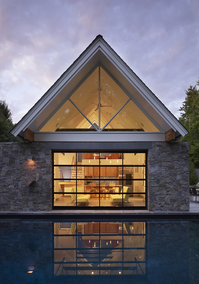 Immagine della facciata di una casa piccola contemporanea a un piano con rivestimento in pietra e tetto a capanna