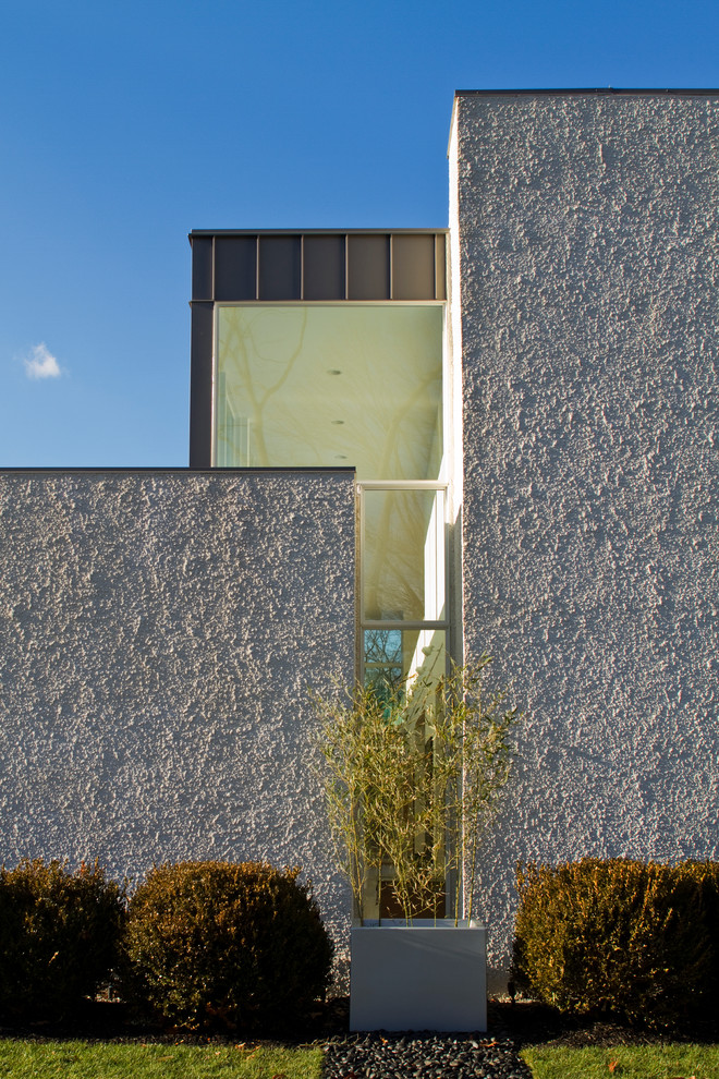 Ejemplo de fachada de casa blanca y gris contemporánea grande de dos plantas con revestimiento de piedra, tejado plano y tejado de varios materiales
