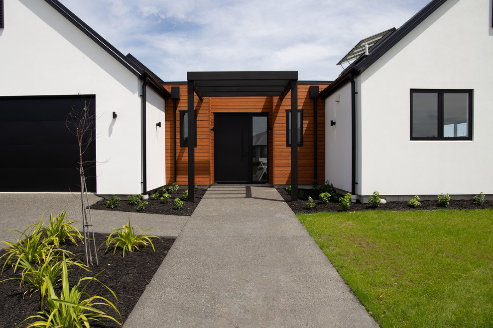 Imagen de fachada de casa multicolor minimalista grande de una planta con revestimiento de estuco, tejado a dos aguas y tejado de metal
