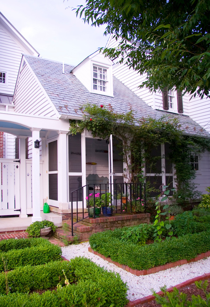 This is an example of a white traditional house exterior in DC Metro with wood cladding.