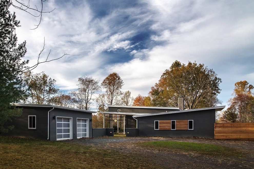 Cette photo montre une façade de maison grise tendance en béton de plain-pied et de taille moyenne avec un toit en appentis.