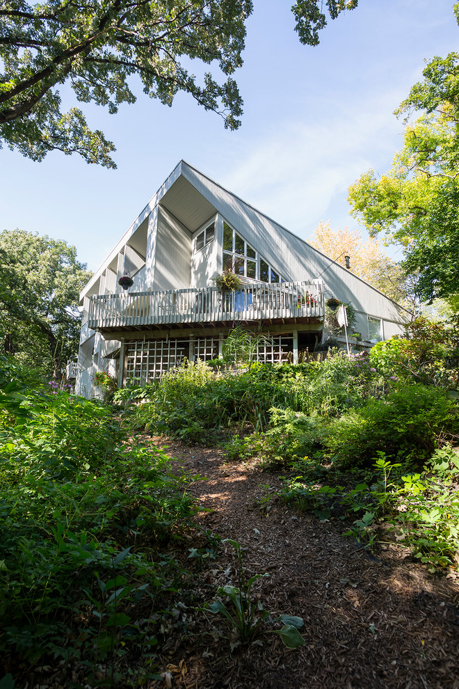 Стильный дизайн: серый частный загородный дом в стиле ретро с комбинированной облицовкой, односкатной крышей и крышей из гибкой черепицы - последний тренд