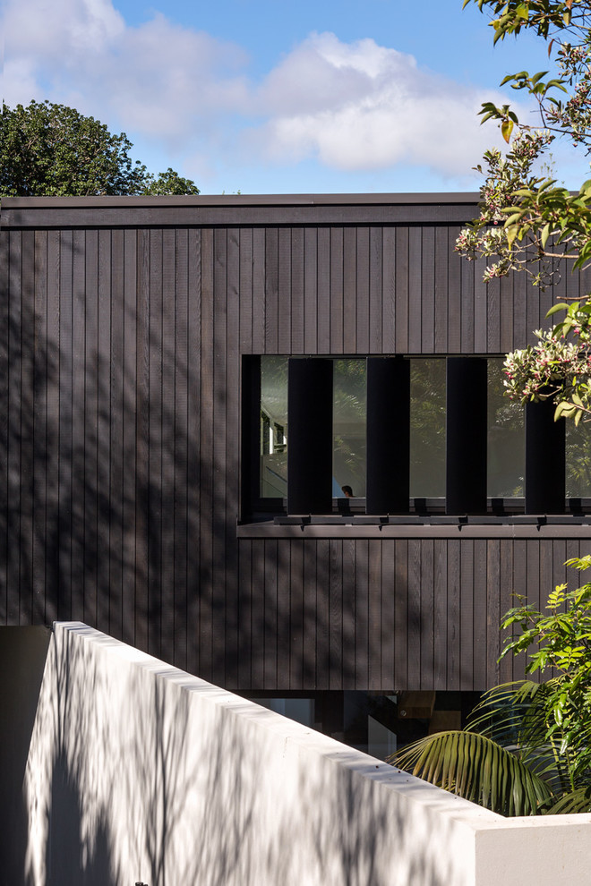 Mittelgroßes, Zweistöckiges Modernes Haus mit brauner Fassadenfarbe, Flachdach und Blechdach in Auckland