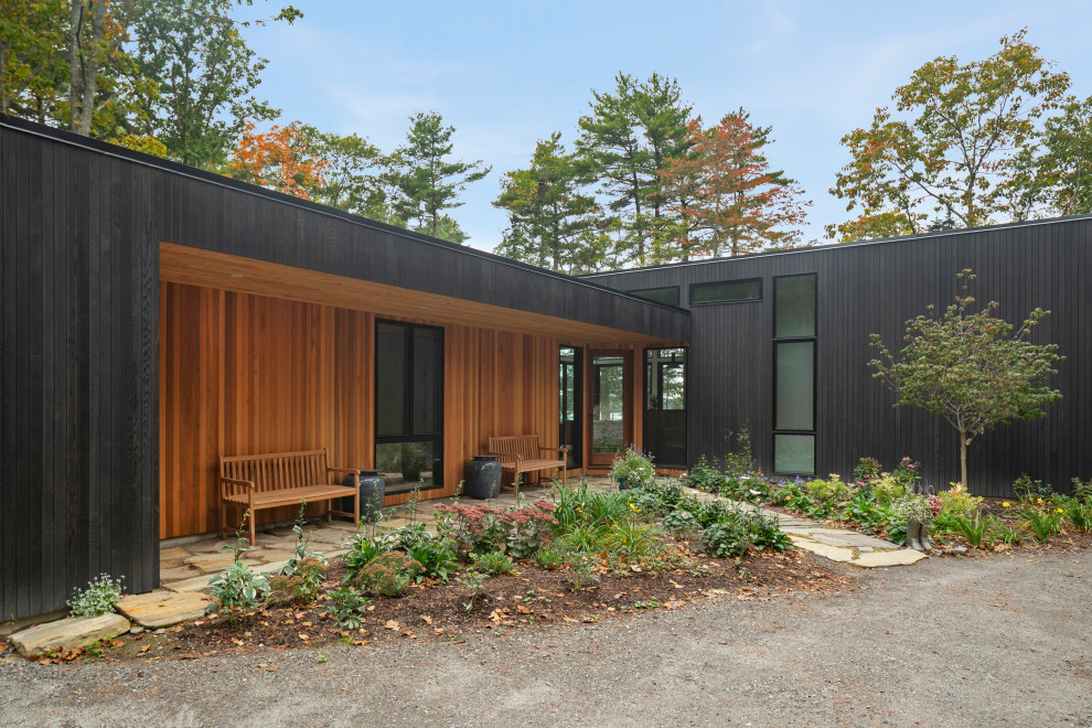 Свежая идея для дизайна: одноэтажный, деревянный, черный частный загородный дом среднего размера в стиле рустика с плоской крышей - отличное фото интерьера