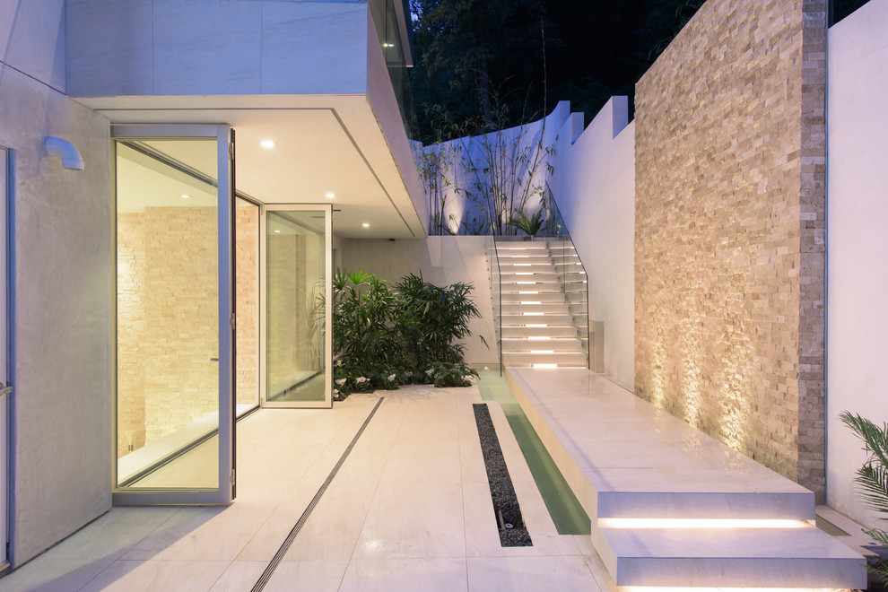 Diseño de fachada de casa blanca contemporánea de tres plantas con revestimiento de estuco y tejado plano