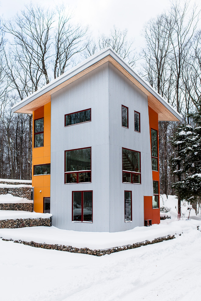 Ejemplo de fachada minimalista de tres plantas con revestimientos combinados