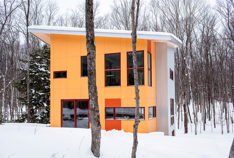 Ejemplo de fachada minimalista de tres plantas con revestimientos combinados
