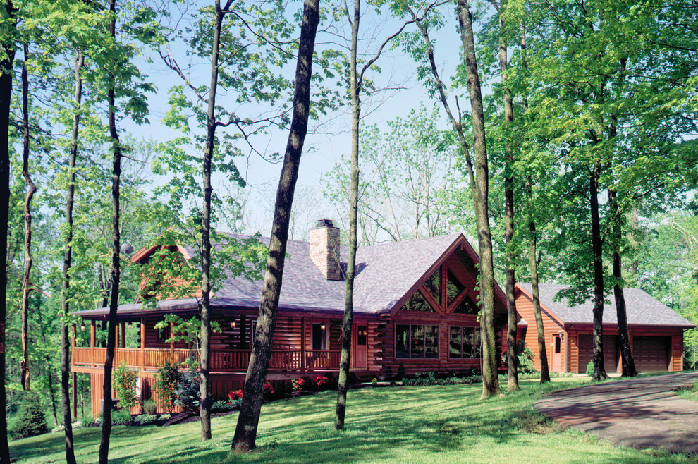 Immagine della facciata di una casa grande marrone rustica a due piani con rivestimento in legno