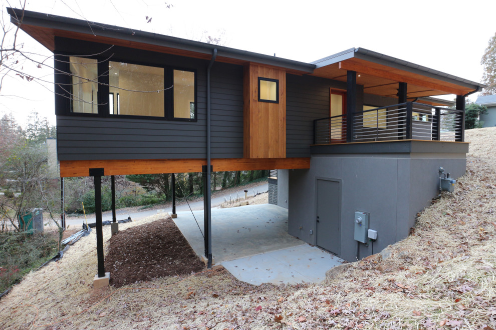 Imagen de fachada de casa gris minimalista a niveles con revestimientos combinados, tejado de un solo tendido y tejado de metal