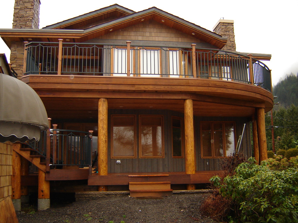 Cette image montre une façade de maison grise craftsman en bois de taille moyenne et à un étage avec un toit à deux pans et un toit en shingle.