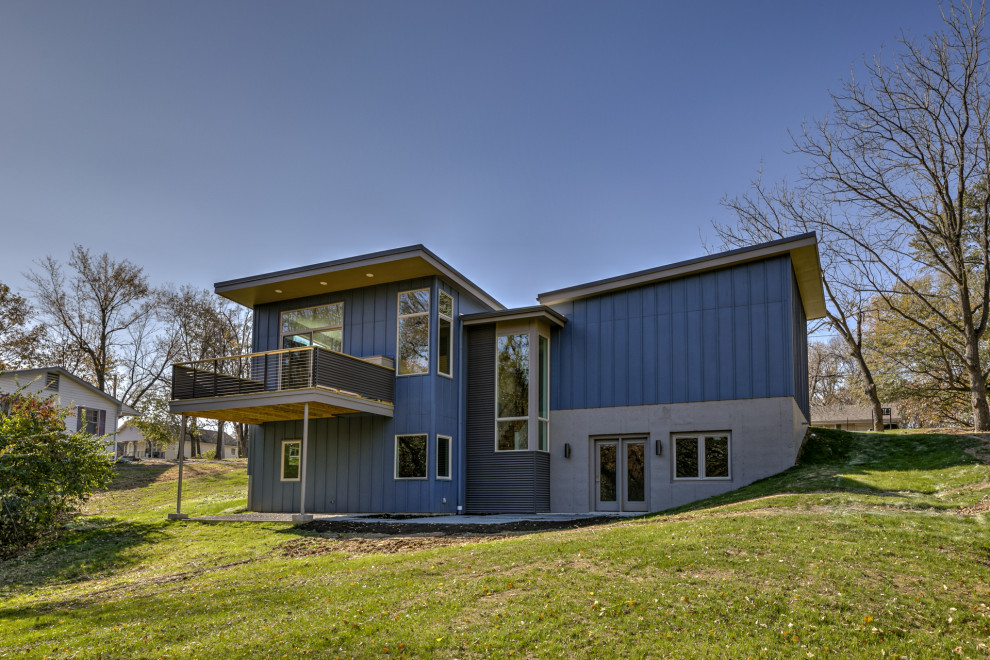 Mid-sized 1950s blue two-story mixed siding house exterior photo in Kansas City with a shed roof and a metal roof