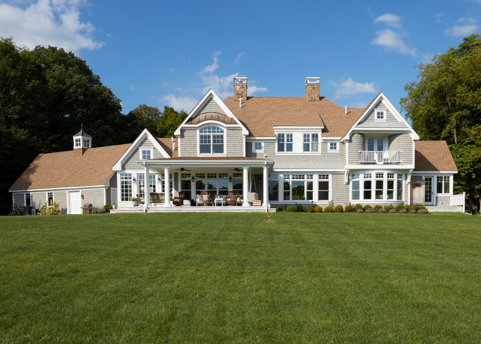 Cette photo montre une très grande façade de maison grise nature en bois à un étage avec un toit à deux pans et un toit en shingle.