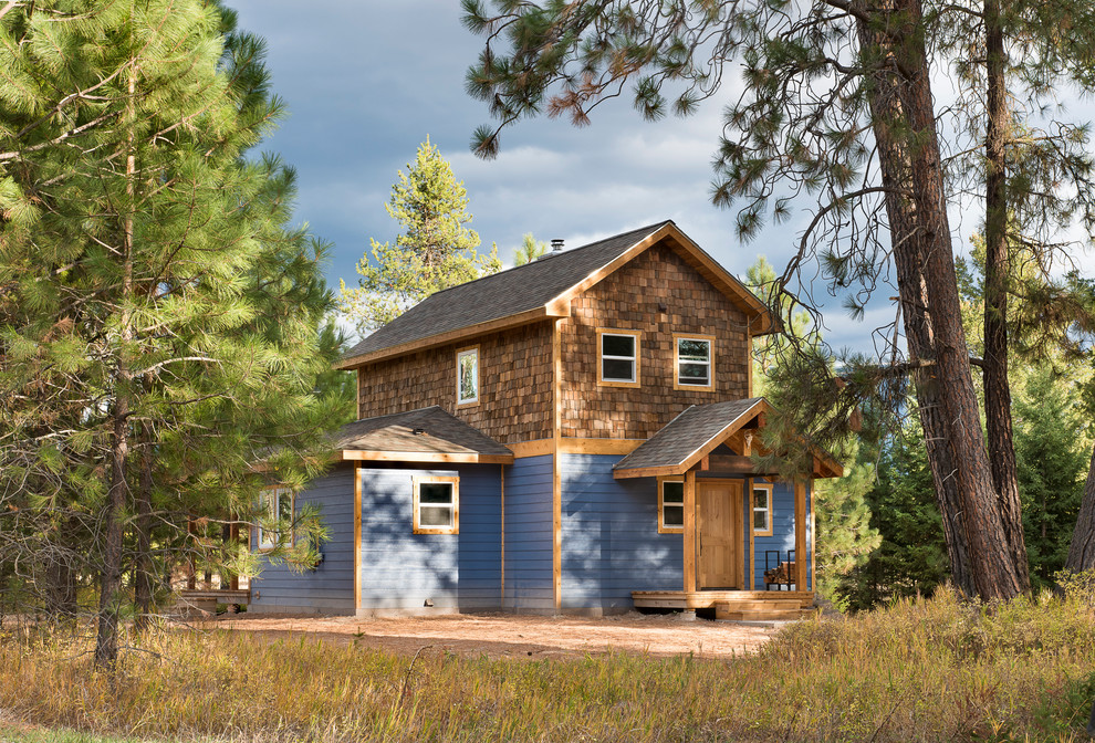 Kleines, Zweistöckiges Uriges Haus mit Mix-Fassade, blauer Fassadenfarbe und Satteldach in Sonstige