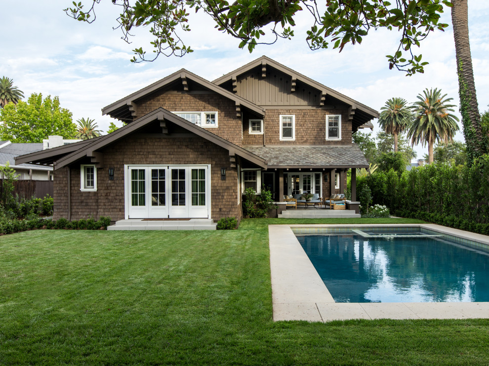 Large and brown classic detached house in Los Angeles with three floors and wood cladding.