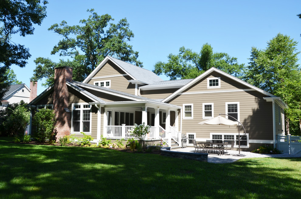 Exemple d'une façade de maison beige chic de taille moyenne et à un étage avec un revêtement en vinyle, un toit à deux pans et un toit en shingle.
