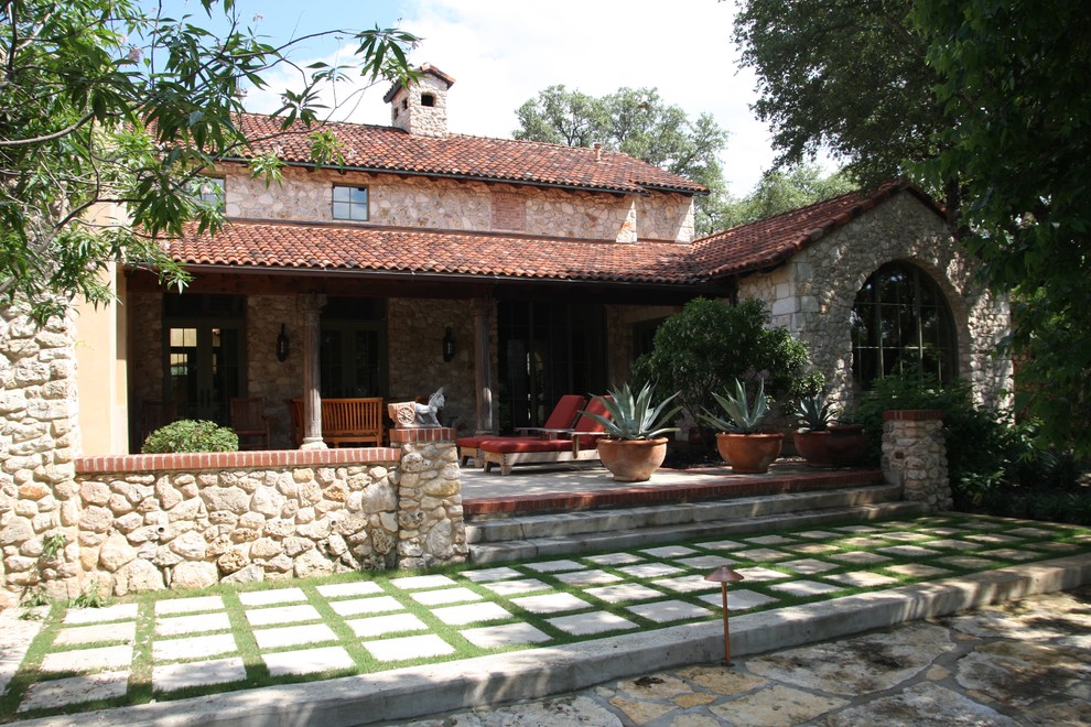 Идея дизайна: дом в средиземноморском стиле с облицовкой из камня и черепичной крышей