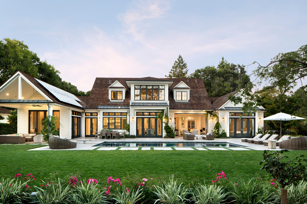 Ejemplo de fachada blanca clásica renovada extra grande de dos plantas con revestimiento de madera y tejado a dos aguas