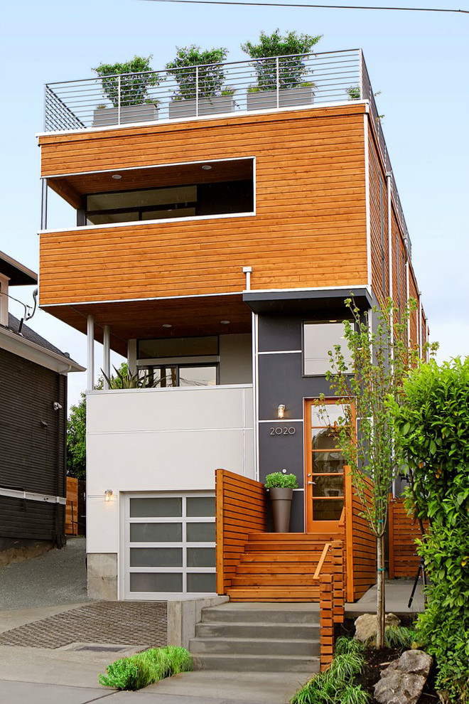 На фото: двухэтажный многоквартирный дом среднего размера в современном стиле с комбинированной облицовкой и плоской крышей с