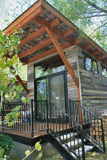Foto della facciata di una casa piccola grigia moderna a un piano con rivestimento in legno e tetto piano