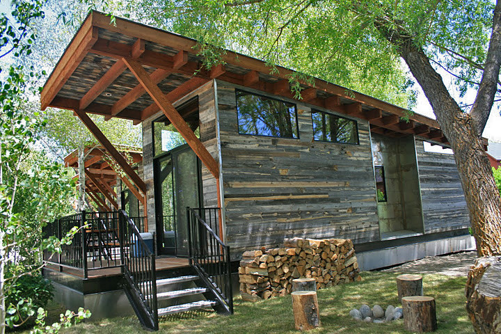 Immagine della facciata di una casa piccola grigia moderna a un piano con rivestimento in legno e tetto piano