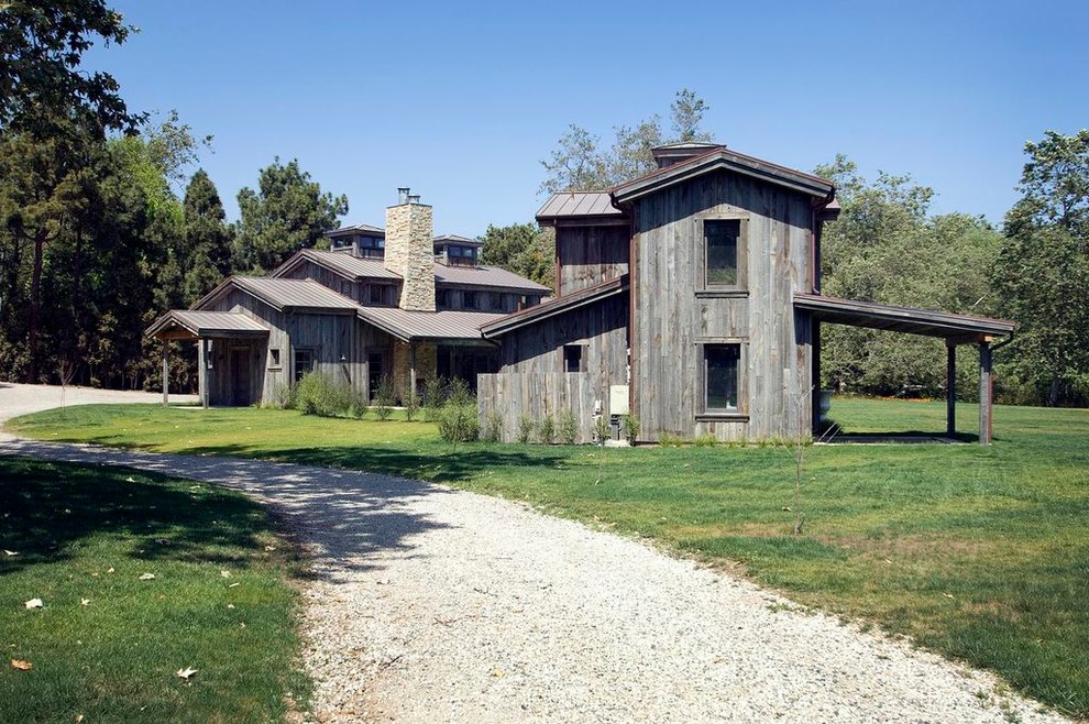 Exempel på ett stort rustikt grått hus, med två våningar, sadeltak och levande tak