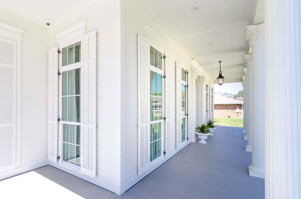 Inspiration for a large timeless white two-story wood exterior home remodel in New Orleans with a hip roof